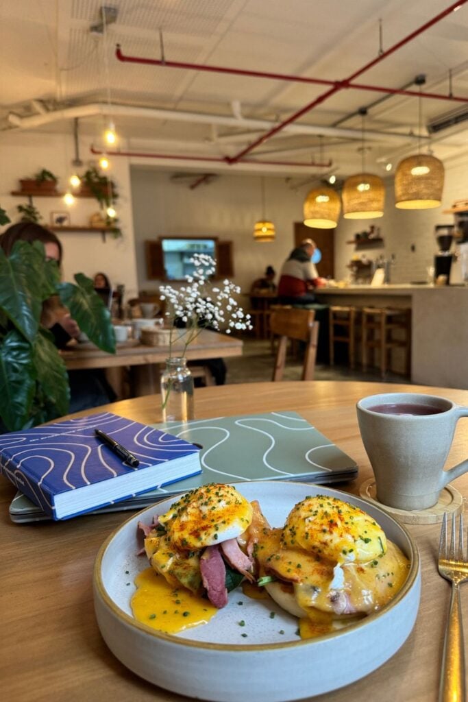 eggs, a notebook and laptop in a cafe in Lima