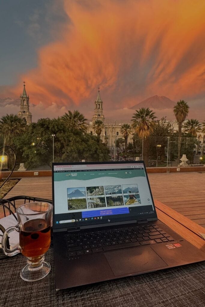 remote working on a rooftop with a laptop, sunset and mountains