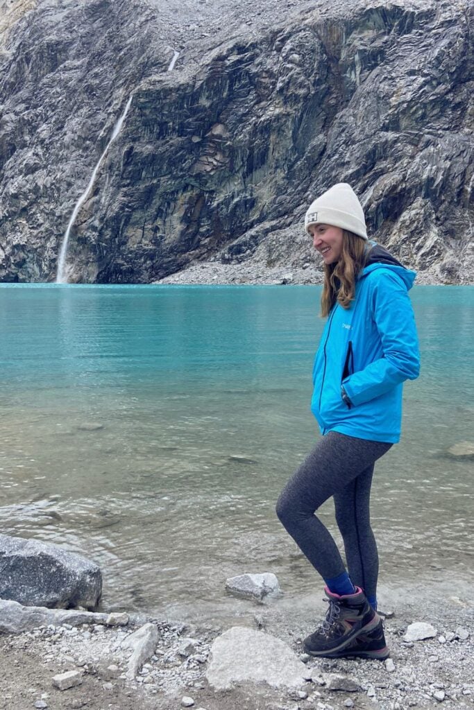 Peru Packing List: From Cusco to the Amazon 7 a girl standing by Laguna 69 in Peru with hiking boots that are recommended in this Peru packing list