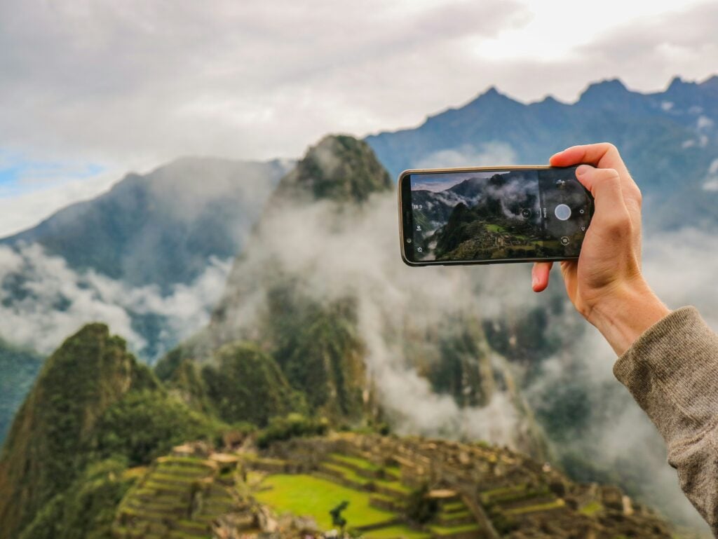 Peru Packing List: From Cusco to the Amazon 4 someone taking a photo with a phone of Machu Pichhu in Peru